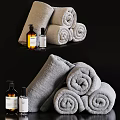 Soft Gray Rolled Towels With Natural Bath Products On Black Surface