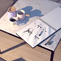 Marble Top Dining Table with Sketchbook with Drawings Cups and Pen Near Gray Sofa