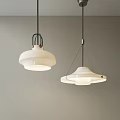 Two Modern White Pendant Lights with Minimalist Design Hanging Against Grey Wall