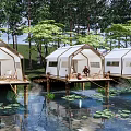 Lakeside Glamping Site with Overwater Platforms White Tents and Wooded Surroundings
