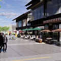 Vibrant Commercial Street With Outdoor Seating Green Umbrellas And Pedestrians Walking