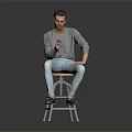 Man In Gray Shirt And Light Blue Jeans Sitting On Bar Stool Holding Smartphone