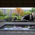Rockery Stones In Garden Courtyard With Green Plants Trees Pool Water Reflections And Wooden Roof
