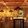 Natural Ambiance Wooden Dining Kitchen Interior With Green Plants Hanging Lights And Dining Table Chairs