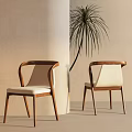 Two Modern Dining Chairs With Wooden Frame And Beige Seat Cushions By Palm Plant