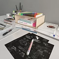 Creative Work Desk with Design Sketches Color Palette Brushes Paints and Hanging Wall Artworks