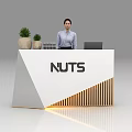 White Exhibition Reception Desk with NUTS Logo Potted Plants and Female Staff