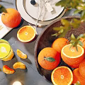 Fresh Oranges In Wooden Bowl With Sliced Oranges And Green Leaves