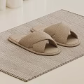 Comfortable Cross Design Beige Slippers On Herringbone Textured Floor Mat