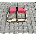 Red Metal Public Parking Lock Facility Installed On Paved Brick Road Surface
