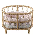 Stylish Wicker Baby Crib With Pink Braided Accents And Gray Comfort Mattress