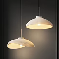Two White Pendant Lights With Rippled Shades Lit Against Dark Background
