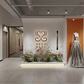 Modern Reception Desk with RENOIR Logo Elegant Gown Mannequin and Green Plants