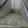 Mossy Broken Brick Stairs With Weathered Concrete Walls And Metal Door