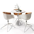 Modern Round White Table And Three Chairs Set With Brown Cushions And Decorative Plant