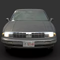 Vintage Dark Gray Sedan With Illuminated Headlights And Silver Rims