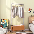 Metal Clothes Rack With Hanging Shirts Coats And Wooden Cabinet In Bedroom With Wall Art And Books