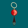 Gold Keychain Pendant With Red Circular Element And Black Peacock Feather Design