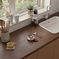 Essential Kitchen Utensils Including Wooden Spoons on Countertop with Coffee Cup and Sink