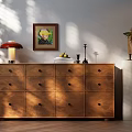 Wooden Dresser with Multiple Drawers Table Lamp Framed Artwork and Potted Plant in Sunlit Room