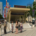 Modern Urban Station Entrance With Tall Buildings Flags Balloons And People Gathering