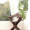Carved Wooden Dining Chair With Green Plants Near Window In Bright Indoor Space