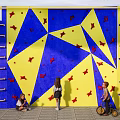 Fun Indoor Kids Climbing Wall with Blue and Yellow Surface and Red Star Shaped Holds