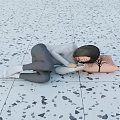 Woman Lying on Gray Speckled Floor Tiles Hugging Pink Pillow With Tree Pattern