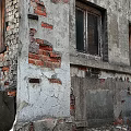 Old Industrial Factory Building with Weathered Roof Red Brick Plaster Walls Peeling Sections and Green Door