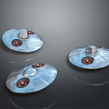 Three Metallic Disc Shaped Objects With Shiny Surface And Red Circular Elements On Dark Background