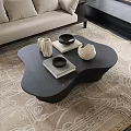 Modern Black Irregular Shape Coffee Table on Beige Rug with White Vases and Books