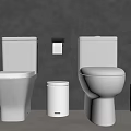 Modern Bathroom With Two White Toilets Small Trash Can And Brush Holder