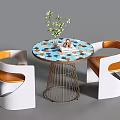 Modern Round Negotiation Table with Colorful Tabletop Metal Legs White Orange Chairs and Small Plant