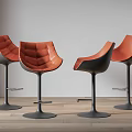 Modern Bar Stools With Orange Leather Upholstered Seats And Sturdy Black Base