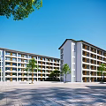 Modern School Building Design With Multi Story White Facade Surrounding Trees And Open Plaza