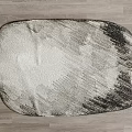 Oval Stylish Rug With Gray And White Abstract Pattern On Wooden Floor