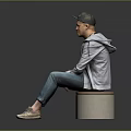A Man Sitting On Cylindrical Stool Wearing Black Cap Gray Jacket And Blue Jeans