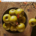 Ceramic Bowl Filled With Green Apples On Wooden Table With Branches And Red Flowers