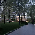 Modern Residential Landscape With High Rise Building Trees Lawn Glass Structure Pathway And Evening Lighting
