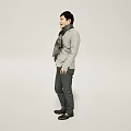 Handsome Man Dressed in Gray Jacket and Black Pants Standing Against Gray Background With Scarf