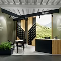 Ritorno Exhibition Booth With Wooden Black Design Wine Rack Vineyard Backdrop Seating And Green Plants