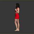 A woman in red dress with curly hair standing against gray background wearing high heels