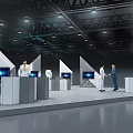 Modern Exhibition Booth With White Stands Digital Screens Lighting And People In White Clothing