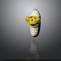 Cartoon Creature Toy Featuring Yellow Head Red Spots Open Mouth White Teeth And Turquoise Body