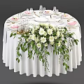 Elegant Round Dining Table With White Tablecloth Stylish Tableware And White Flower Centerpiece Green Foliage