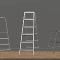 Silver Metal Ladders Three Different Sizes Against Gray Wall On Wooden Floor