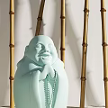 Light Green Laughing Buddha Sculpture With Clasped Hands Beads And Bamboo Background