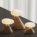 Three Mushroom Shaped Table Lamps With Sandstone Base And White Lampshade On Dark Tabletop