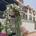 Residential Landscape With Iron Gate Flower Arch White Flowers Green Vines And Surrounding Colorful Plants