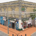 Vintage Yellow Building Featuring Multiple Shops And Colorful Storefronts On Red Brick Street